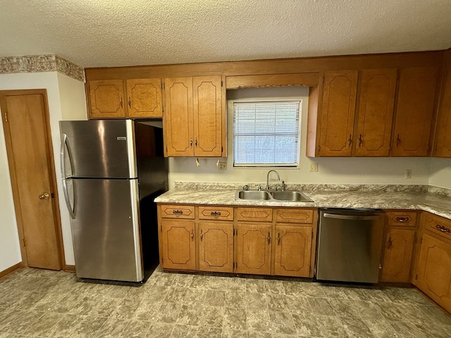 kitchen with sink, a textured ceiling, and appliances with stainless steel finishes