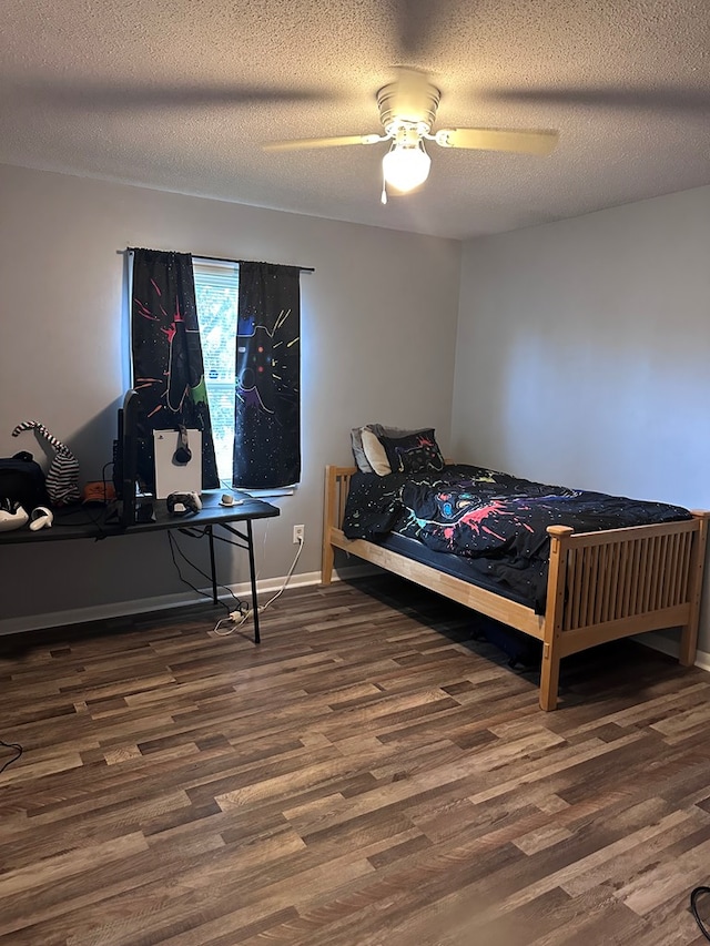 bedroom featuring baseboards, a textured ceiling, ceiling fan, and wood finished floors