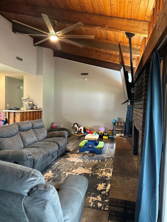 living area featuring a ceiling fan, visible vents, a fireplace, wooden ceiling, and beamed ceiling