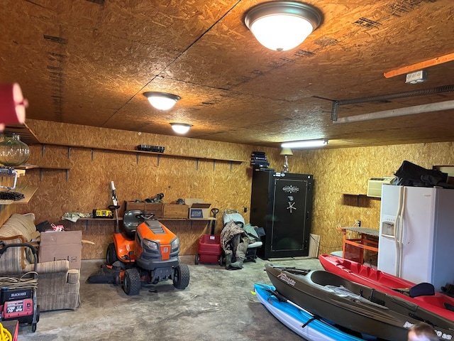 garage with a workshop area and white fridge with ice dispenser