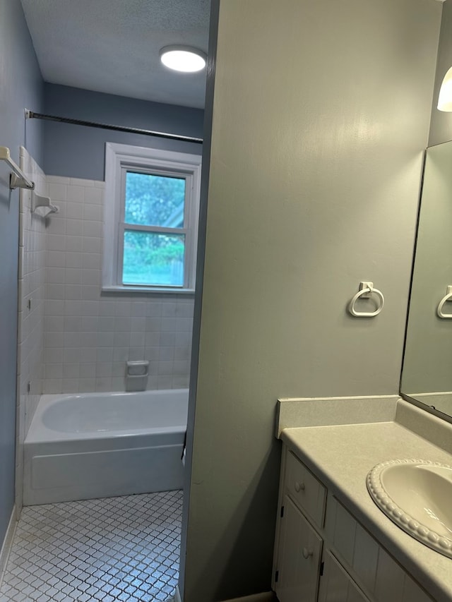 bathroom featuring tile patterned flooring, shower / washtub combination, a textured ceiling, and vanity