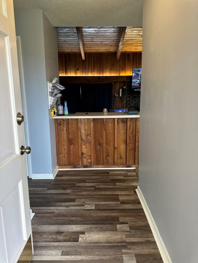 kitchen with beamed ceiling, baseboards, dark wood finished floors, and brown cabinetry