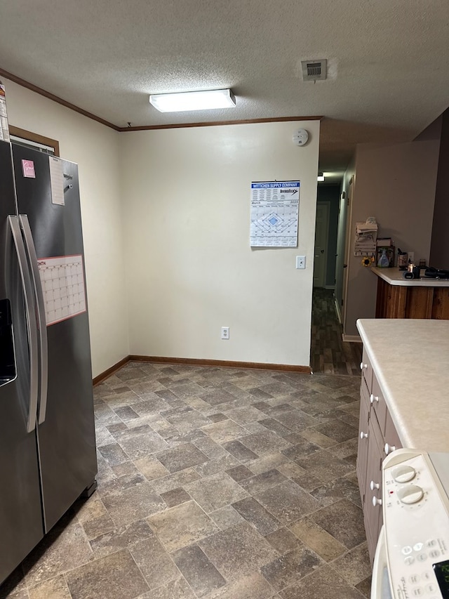 kitchen with visible vents, stainless steel fridge with ice dispenser, ornamental molding, light countertops, and range