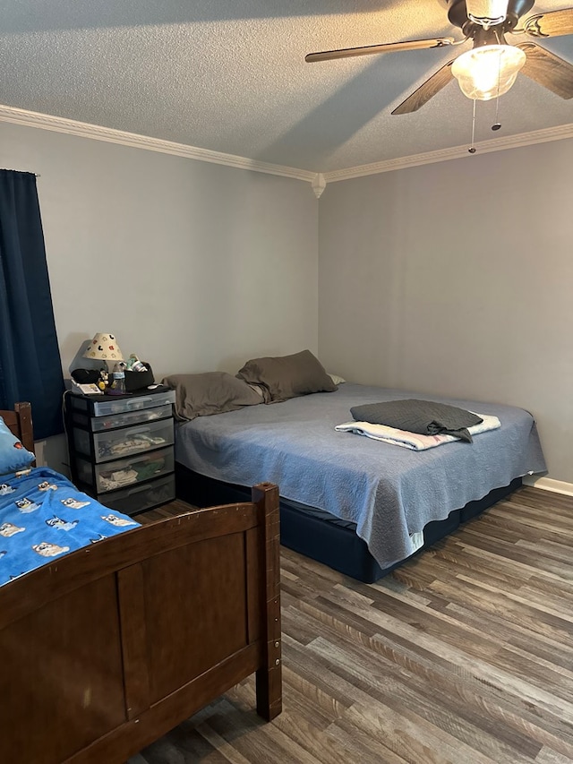 bedroom with ornamental molding, a textured ceiling, a ceiling fan, and wood finished floors