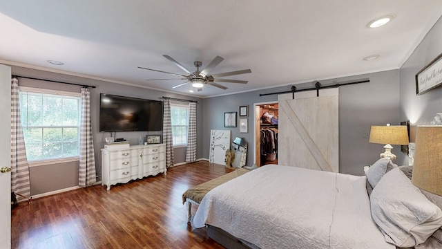 514 S Main St, Headland, AL 36345 - bedroom featuring a barn door, ornamental molding, baseboards, multiple windows, and wood finished floors