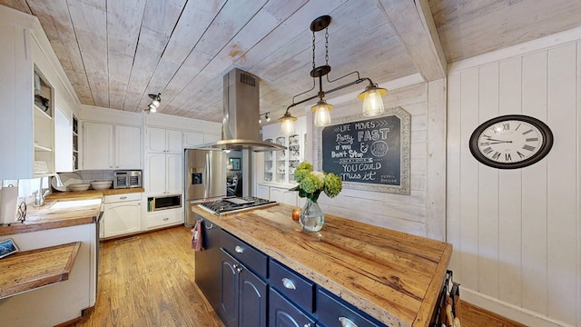 514 S Main St, Headland, AL 36345 - kitchen featuring blue cabinets, butcher block counters, island range hood, stainless steel appliances, and light wood-style floors