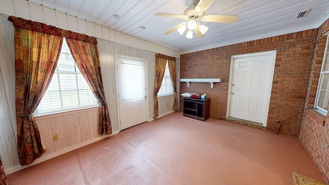 412 Darlington Cir, Dothan, AL 36301 - unfurnished living room with brick wall, plenty of natural light, wood walls, and a ceiling fan