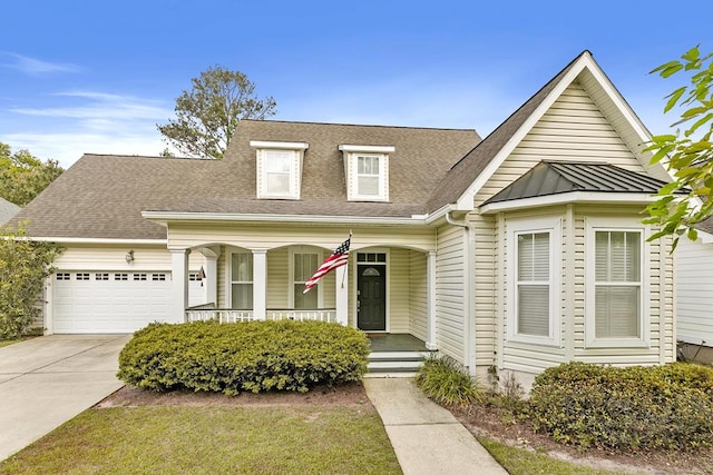 view of front facade with an attached garage, driveway, roof with shingles, and covered porch