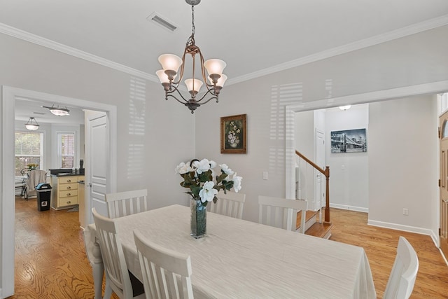dining space with light wood-style flooring, visible vents, a chandelier, and ornamental molding