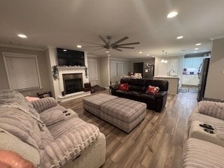 living room with wood-type flooring, ceiling fan, and crown molding