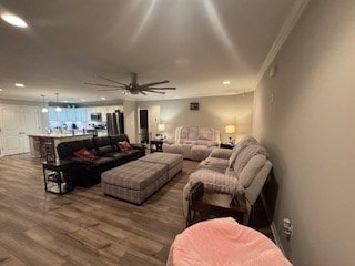 living room featuring ceiling fan, ornamental molding, and hardwood / wood-style floors