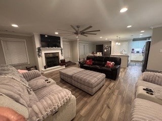 living room with ceiling fan, crown molding, and wood-type flooring