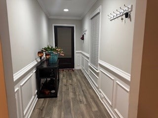 hallway with dark wood-type flooring and crown molding