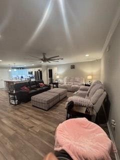 living room featuring ornamental molding, ceiling fan, and wood-type flooring