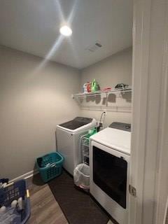 laundry area featuring hardwood / wood-style flooring and washing machine and dryer