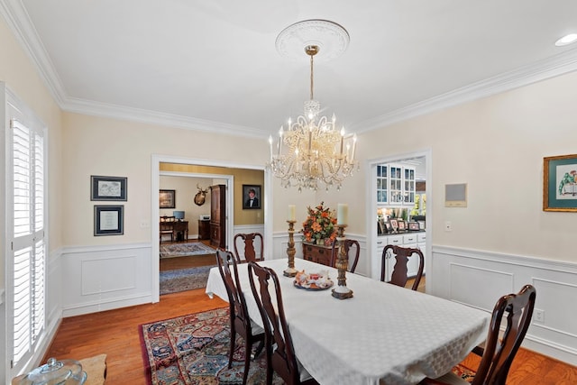 dining space featuring a healthy amount of sunlight, ornamental molding, and light hardwood / wood-style flooring