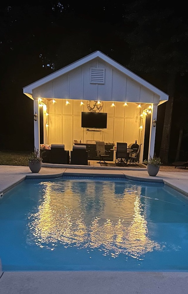 view of pool with an outdoor living space, an outbuilding, and a patio