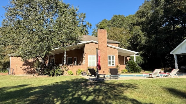 back of property with a yard and a patio area