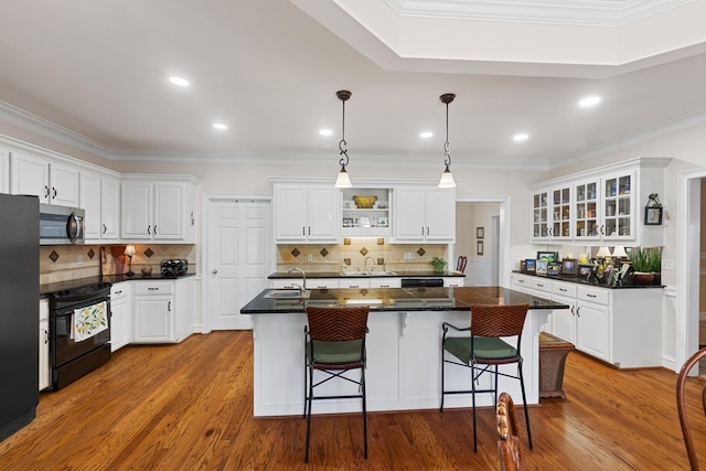 kitchen with white cabinetry, a center island with sink, hardwood / wood-style floors, and black electric range