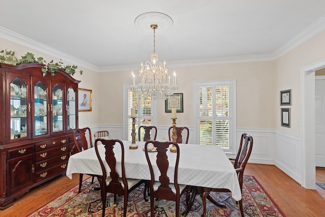 dining area featuring a chandelier, crown molding, and light hardwood / wood-style flooring