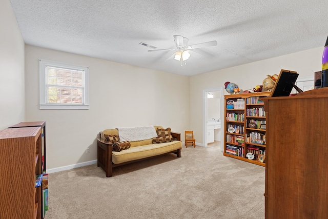 living area featuring light carpet and a textured ceiling