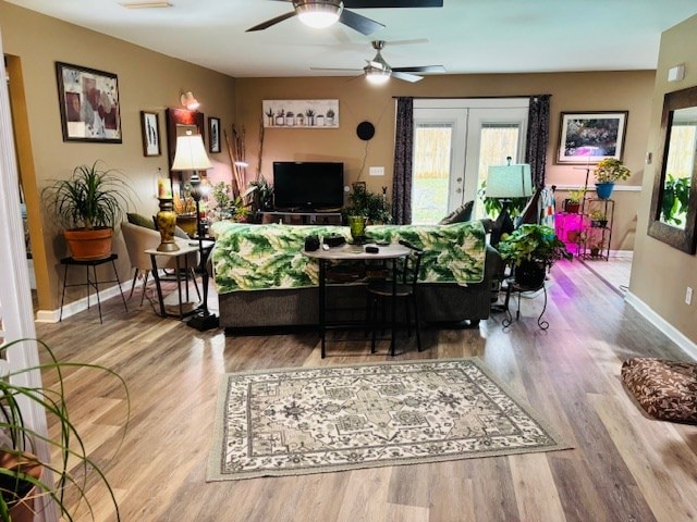 living room featuring a healthy amount of sunlight, french doors, and light hardwood / wood-style flooring