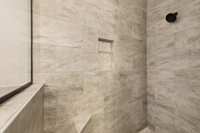 interior details featuring a tile shower