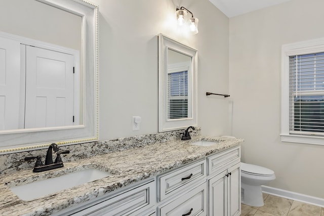 bathroom with toilet, vanity, and tile patterned floors