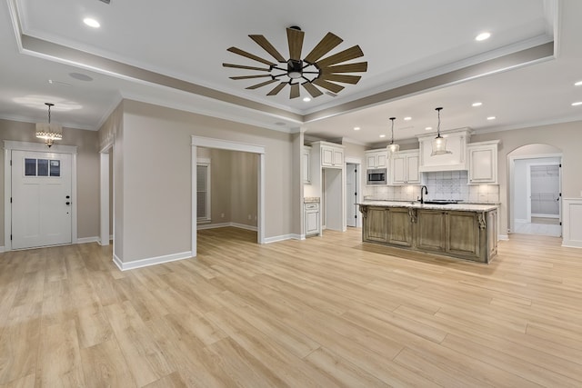 kitchen featuring pendant lighting, white cabinets, a spacious island, and light hardwood / wood-style flooring