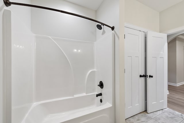 bathroom featuring hardwood / wood-style flooring and bathing tub / shower combination