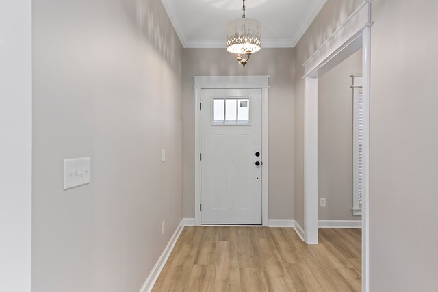 foyer with light hardwood / wood-style floors, ornamental molding, and a notable chandelier