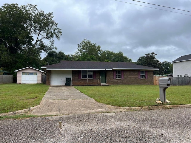 ranch-style home with a front lawn, a garage, and an outbuilding