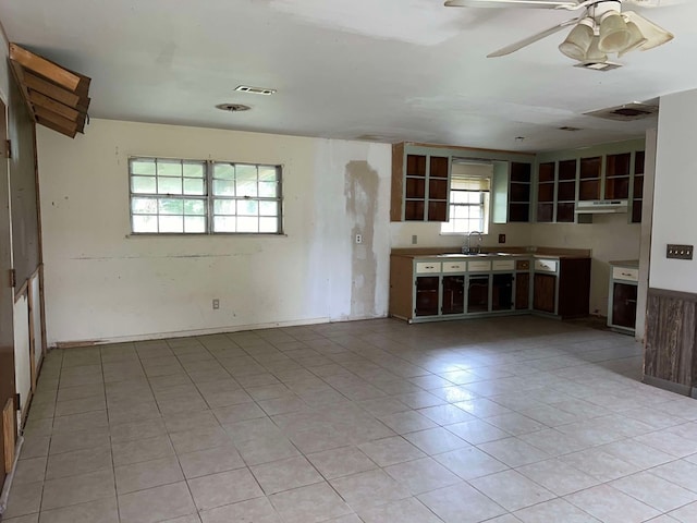 kitchen featuring ceiling fan, sink, a healthy amount of sunlight, and light tile patterned flooring