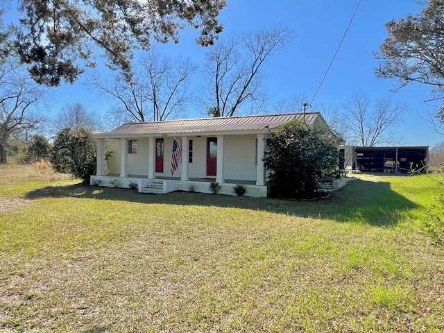 view of front of house with a porch, metal roof, and a front yard