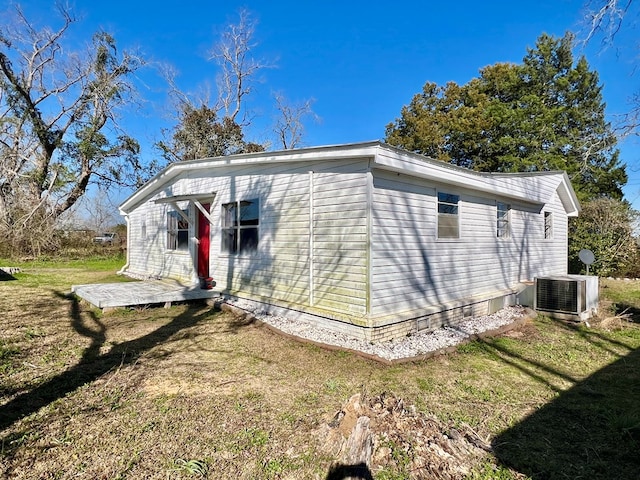 view of property exterior with a yard and central AC