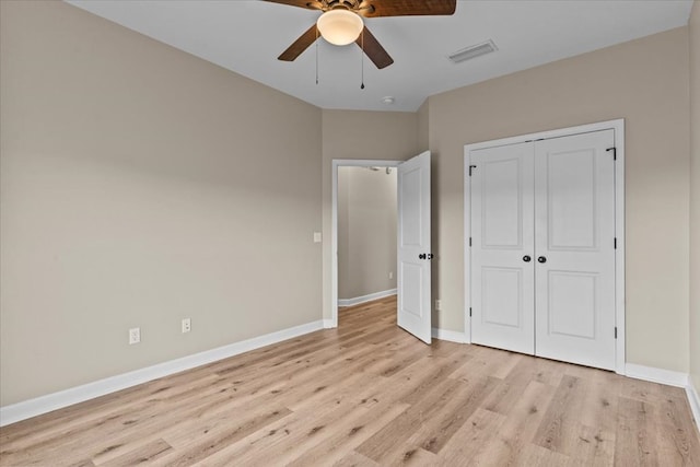 unfurnished bedroom with baseboards, a closet, light wood-style flooring, and visible vents