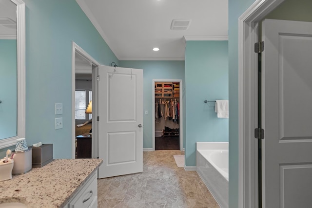 full bathroom featuring baseboards, a walk in closet, crown molding, vanity, and a bath