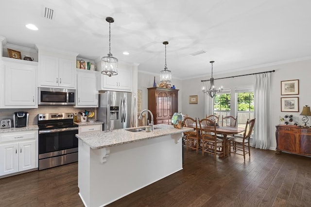 kitchen featuring a kitchen island with sink, a sink, white cabinets, appliances with stainless steel finishes, and light stone countertops