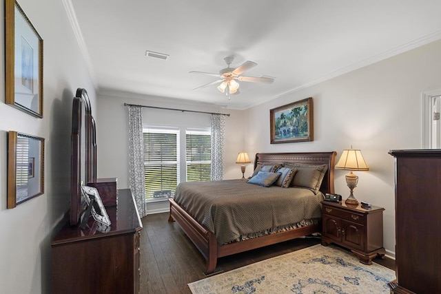 bedroom with crown molding, visible vents, dark wood-type flooring, a ceiling fan, and baseboards