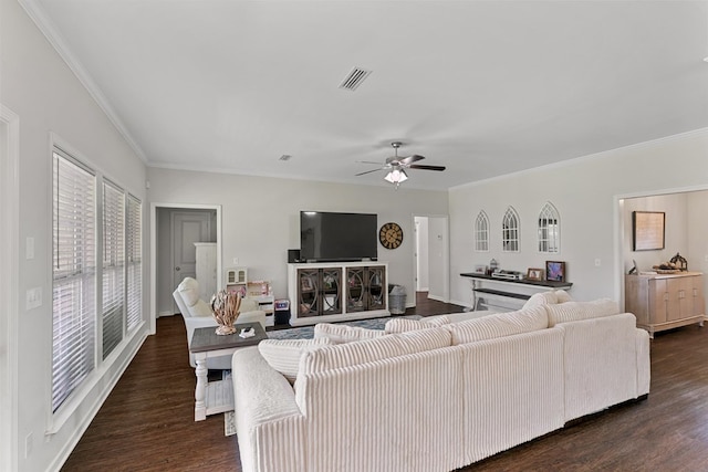 living room with a ceiling fan, crown molding, visible vents, and dark wood-type flooring
