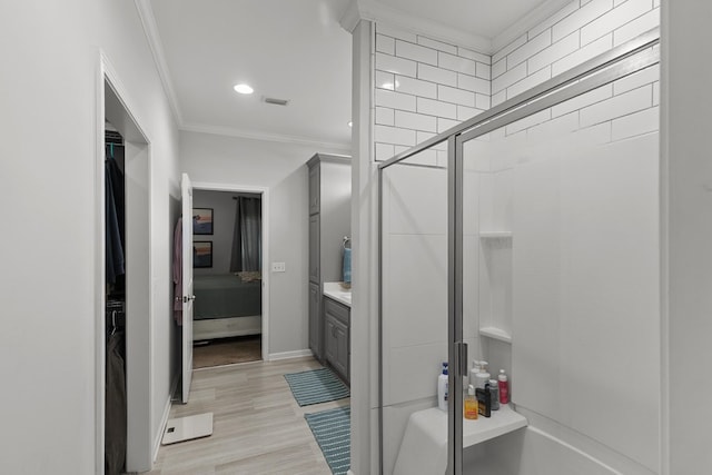 full bath featuring a stall shower, crown molding, baseboards, and wood finished floors