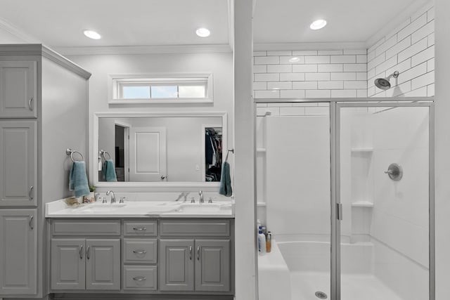 full bath featuring a sink, ornamental molding, and a shower stall