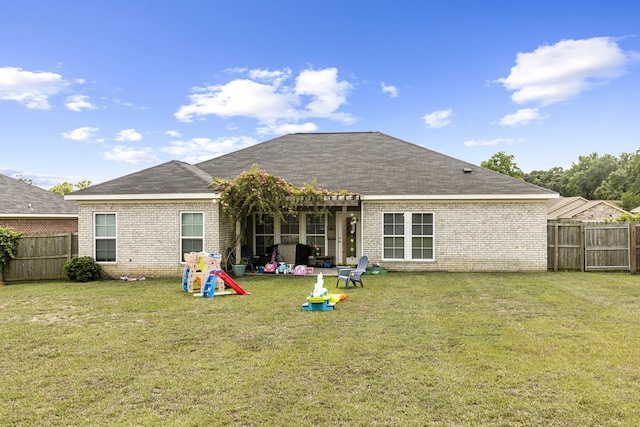 back of property featuring a yard, brick siding, and a fenced backyard