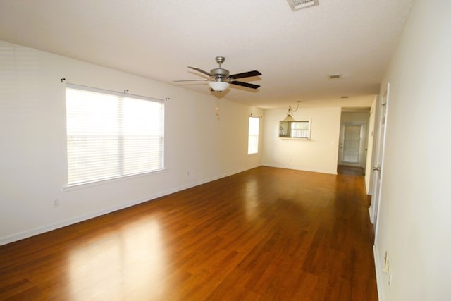 spare room featuring dark hardwood / wood-style floors, ceiling fan, and a textured ceiling