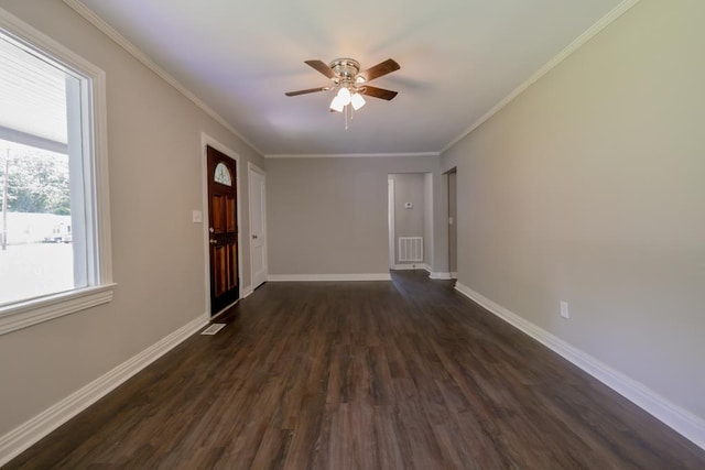 interior space with ceiling fan, ornamental molding, and dark wood-type flooring