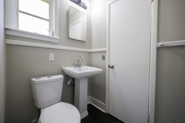 bathroom featuring sink, toilet, and tile walls