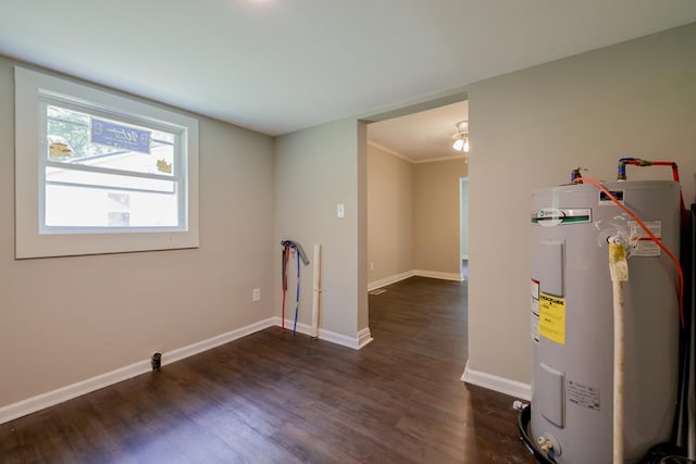 interior space featuring dark hardwood / wood-style flooring, ornamental molding, and water heater