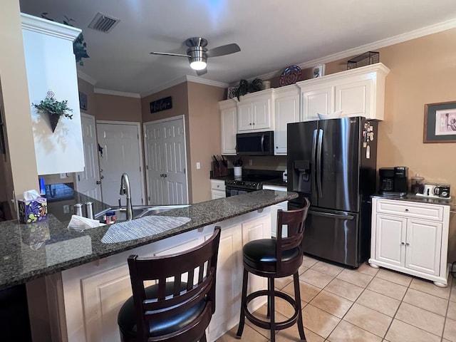 kitchen with crown molding, visible vents, white cabinetry, light tile patterned flooring, and black appliances