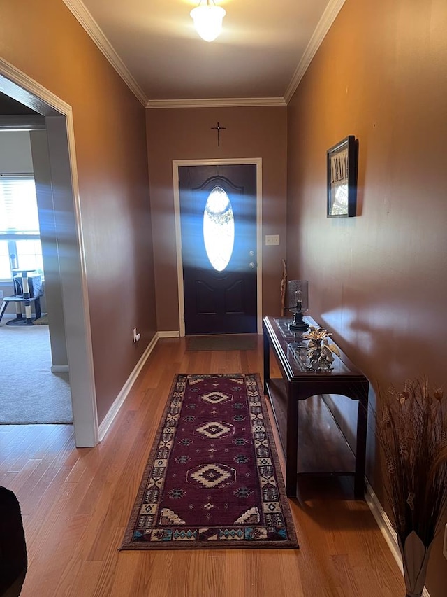 entryway with ornamental molding, baseboards, and wood finished floors