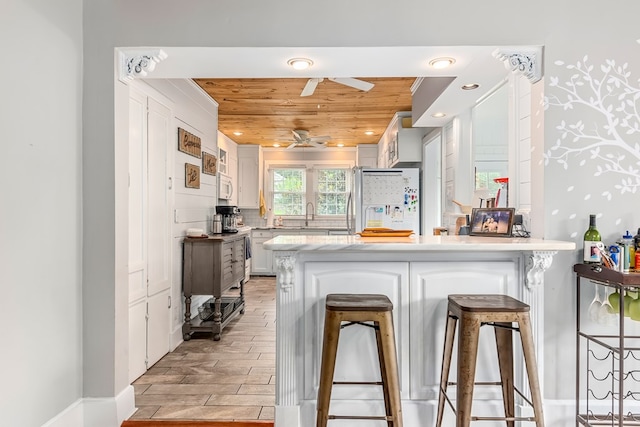 702 W Lee St, Enterprise, AL 36330 - kitchen with white appliances, wood ceiling, a peninsula, a ceiling fan, and light wood-style flooring